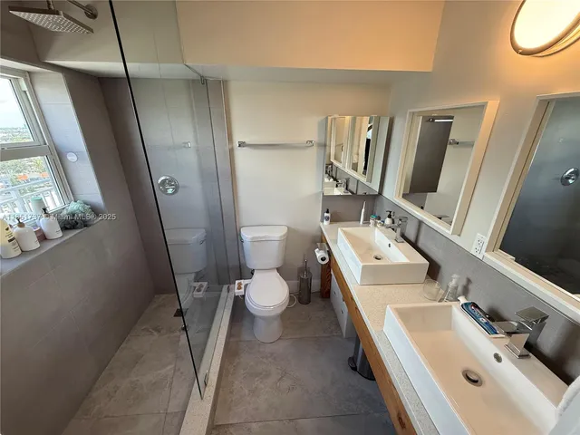 a bathroom with a sink a toilet and a mirror