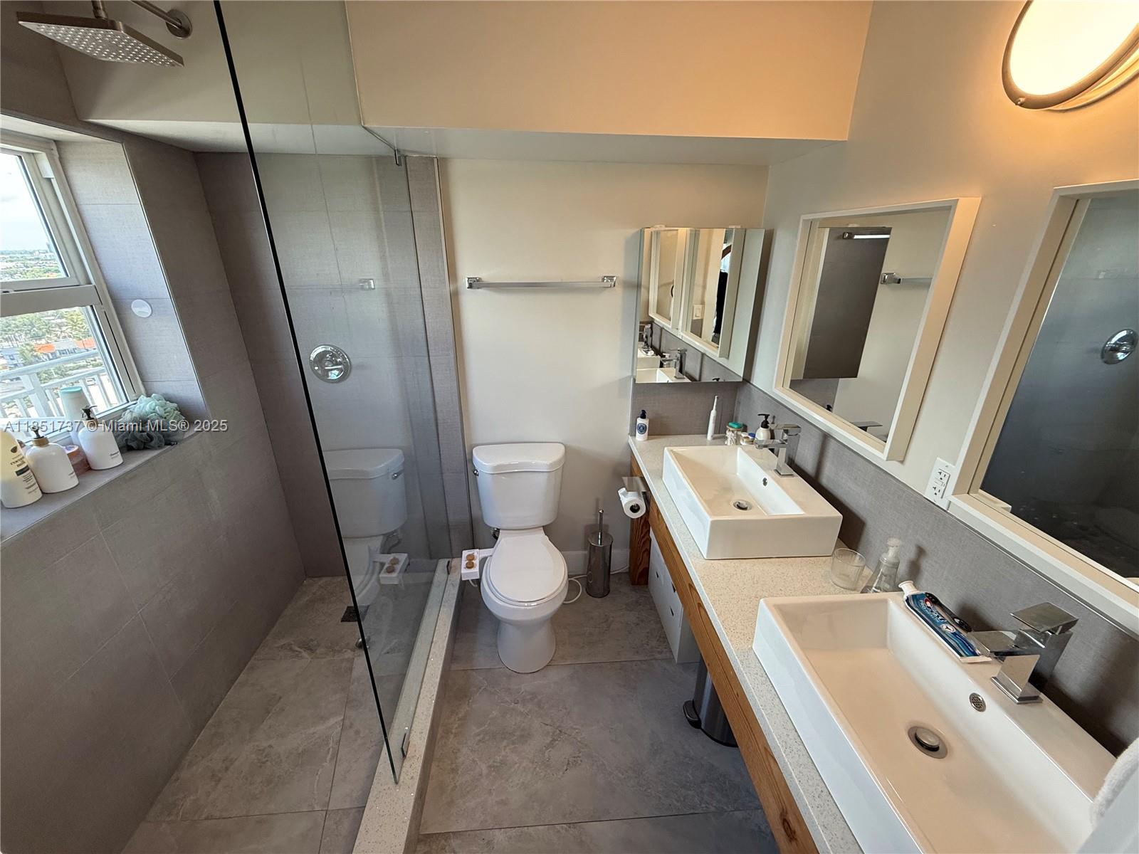 2100 Sans Souci Boulevard, Unit B1406 North Miami, FL 33181 - Photo 4 of 17 a bathroom with a sink a toilet and a mirror