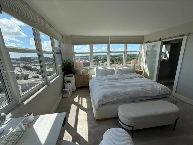 a bedroom with a bed couch and a large window
