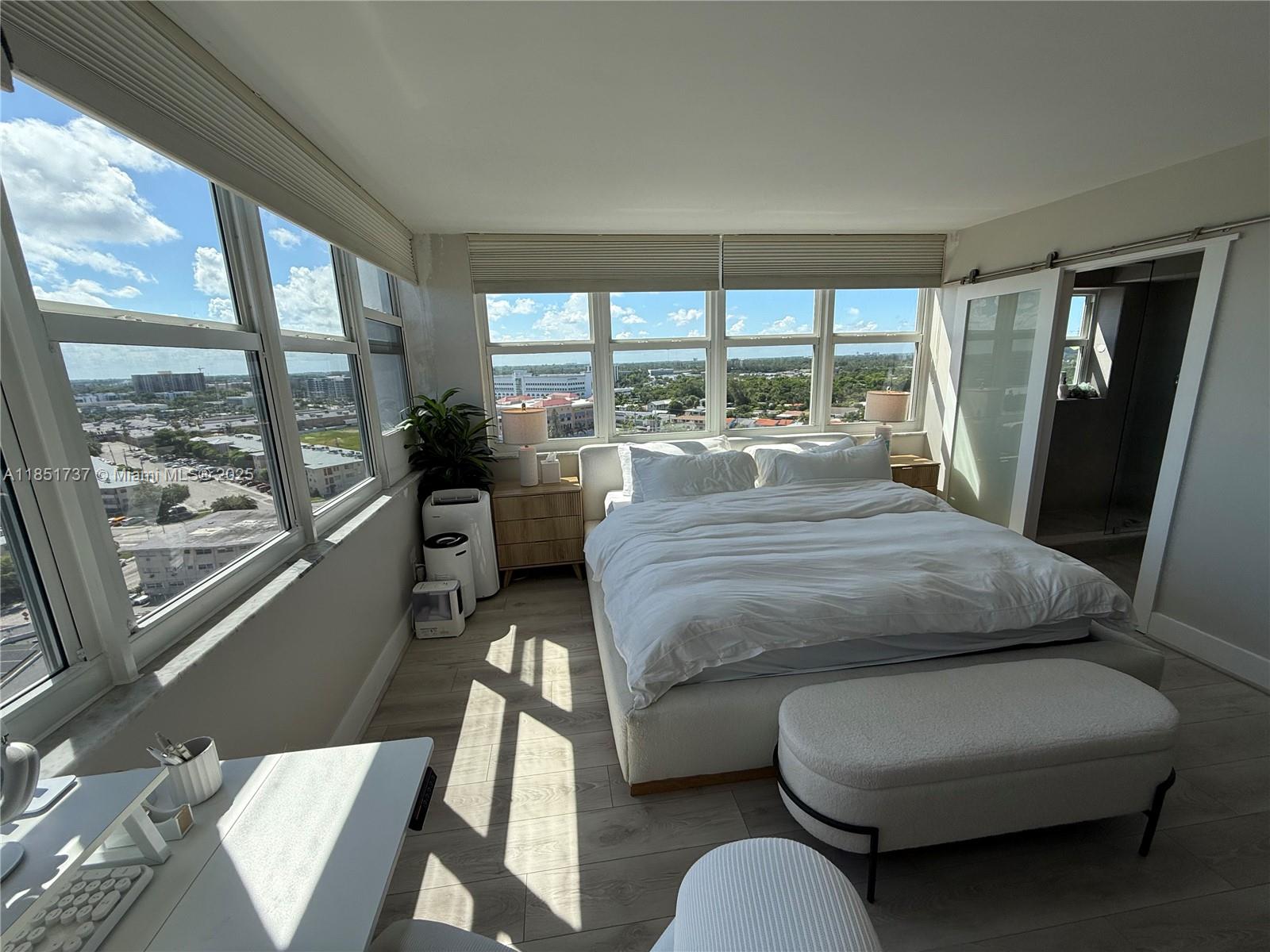 2100 Sans Souci Boulevard, Unit B1406 North Miami, FL 33181 - Photo 5 of 17 a bedroom with a bed couch and a large window