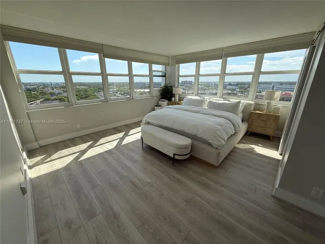 a spacious bedroom with a bed and a large window