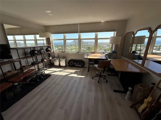 a living room with furniture a fireplace and large windows