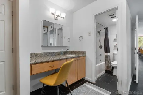 a bathroom with a granite countertop double vanity sink and a mirror
