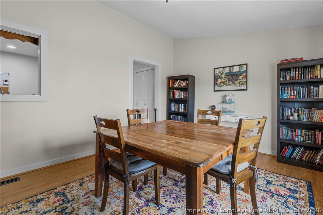 205 Violet Road Dunn, NC 28334 - Photo 12 of 31 a view of a dining room with furniture and a book shelf