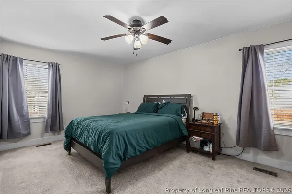a spacious bedroom with a bed and a chandelier