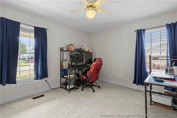 a view of a workspace with furniture and a window