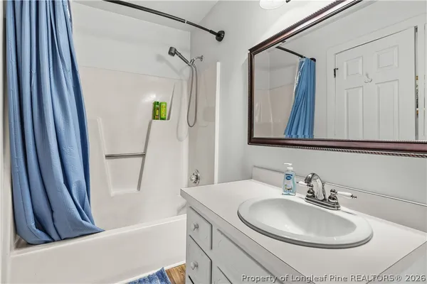 a bathroom with a sink a toilet a shower curtain and a mirror
