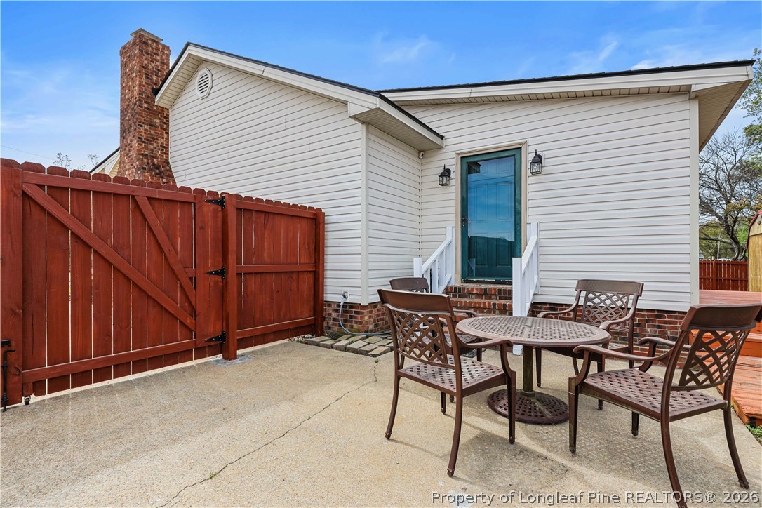 205 Violet Road Dunn, NC 28334 - Photo 23 of 31 a backyard of a house with barbeque oven table and chairs