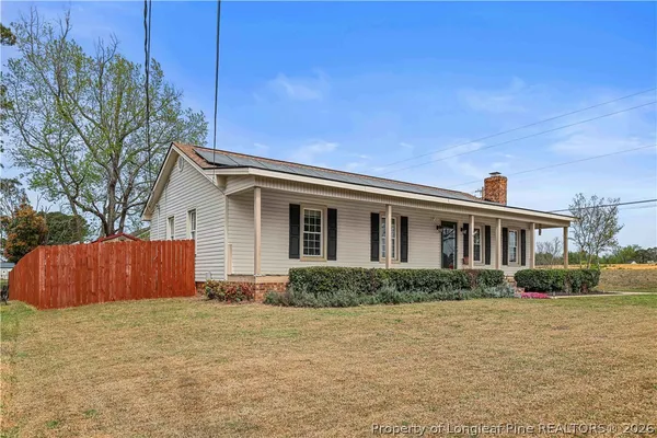 a front view of house with yard and trees around