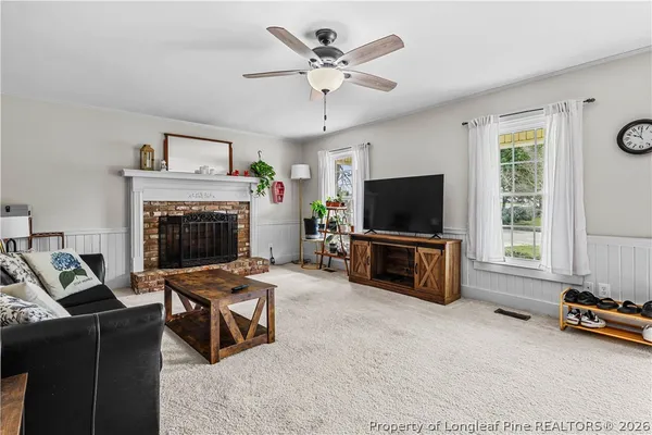 a living room with furniture a flat screen tv and a fireplace
