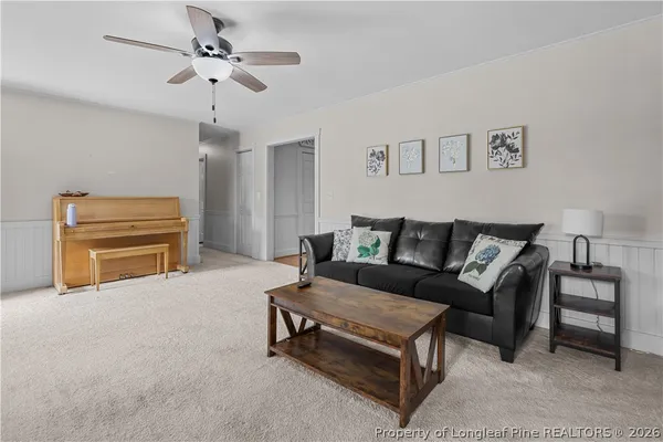 a living room with furniture and a ceiling fan