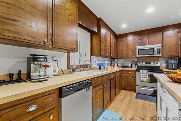 a kitchen with kitchen island granite countertop a sink counter top space appliances and cabinets
