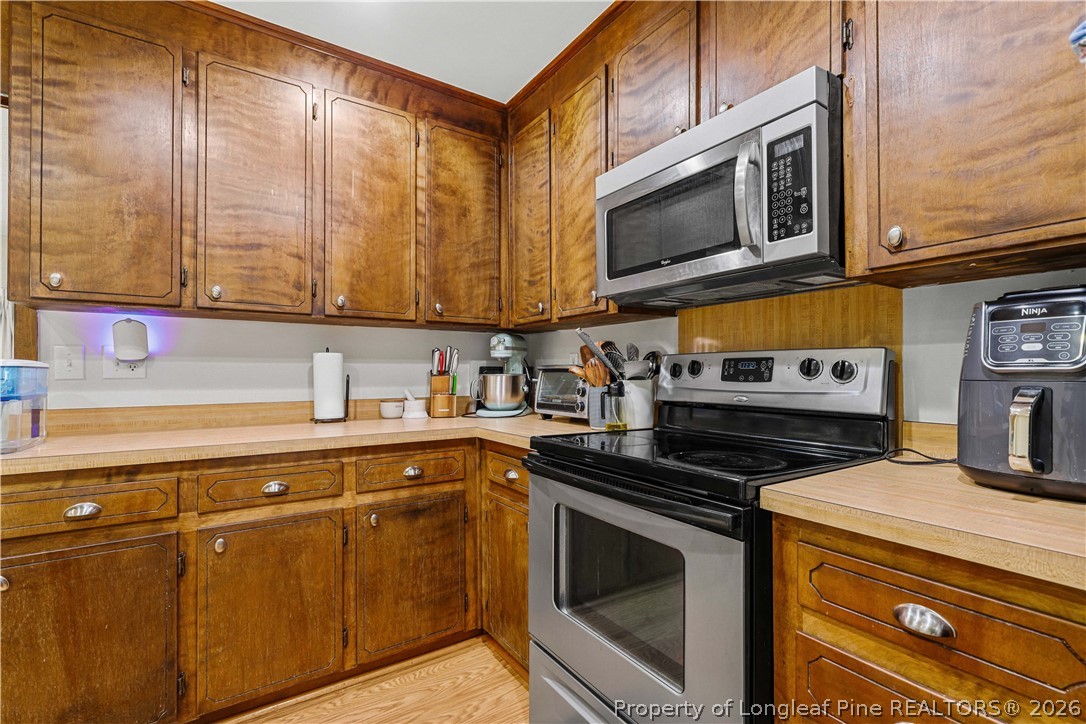 205 Violet Road Dunn, NC 28334 - Photo 10 of 31 a kitchen with stainless steel appliances granite countertop a stove and a microwave