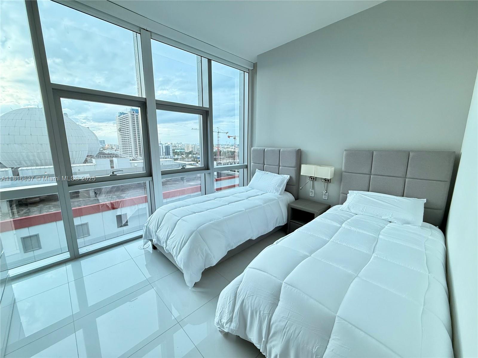 851 Northeast 1st Avenue, Unit 1108 Miami, FL 33132 - Photo 26 of 42 a bedroom with two beds and a large window