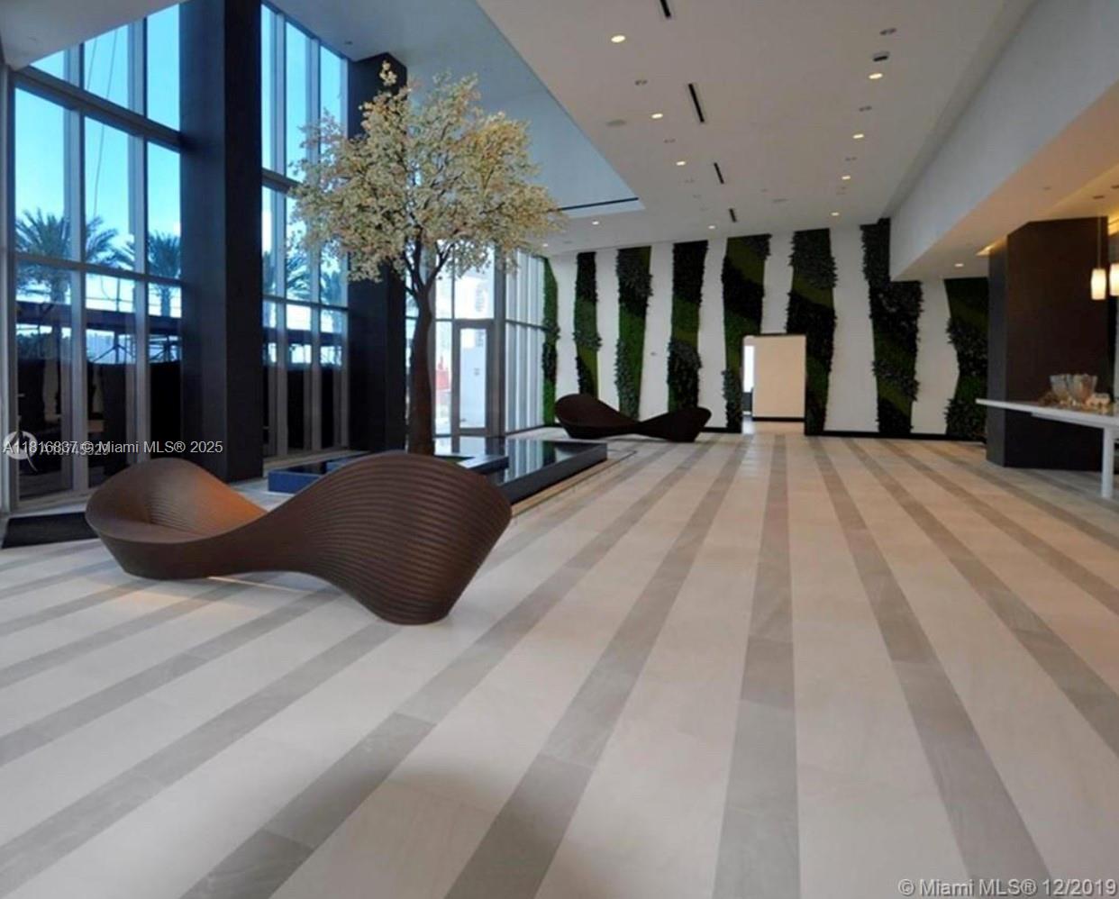 851 Northeast 1st Avenue, Unit 1108 Miami, FL 33132 - Photo 29 of 42 a bedroom with a large bed and a chandelier