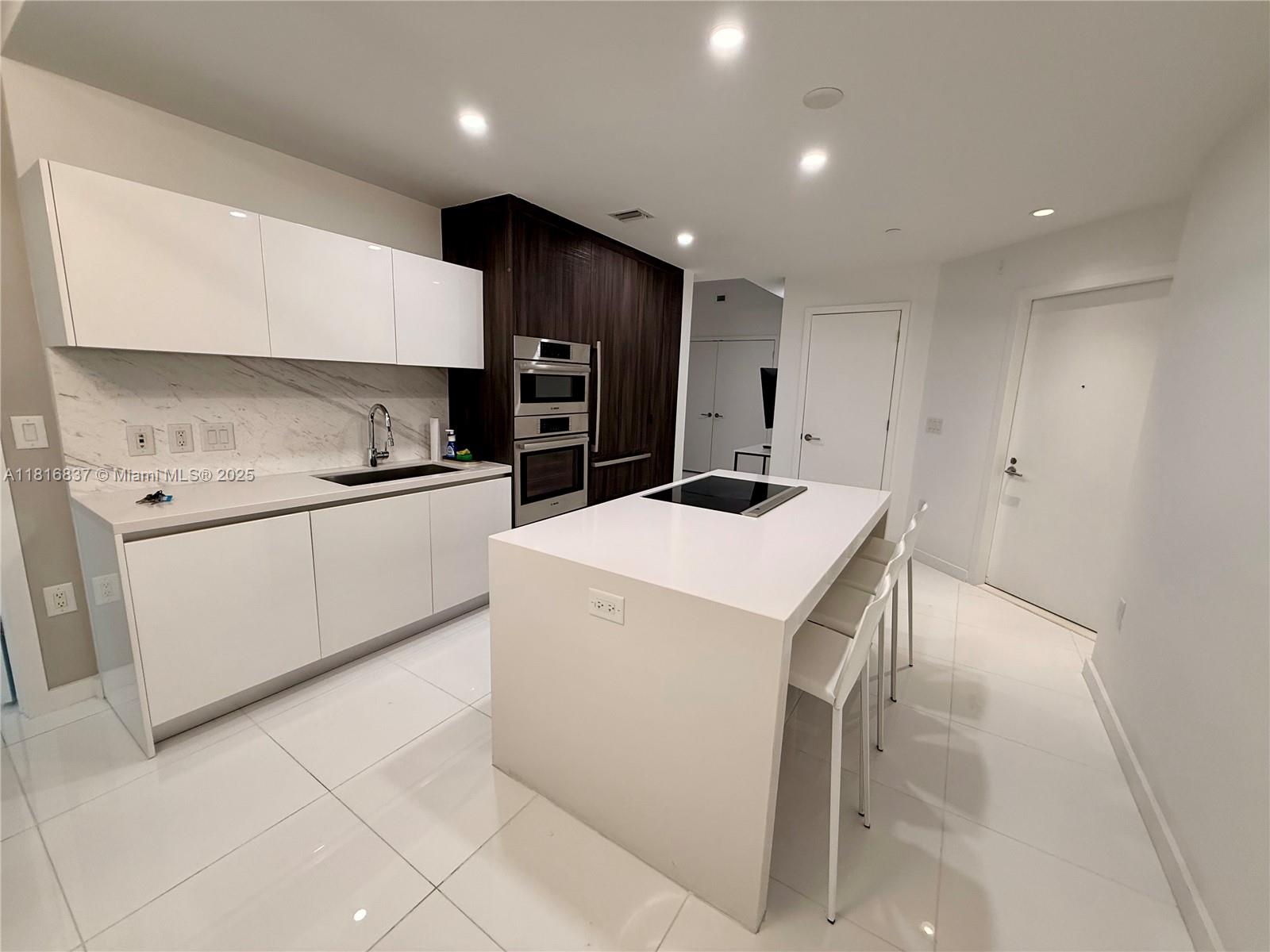 851 Northeast 1st Avenue, Unit 1108 Miami, FL 33132 - Photo 8 of 42 a kitchen that has a sink and a stove in it