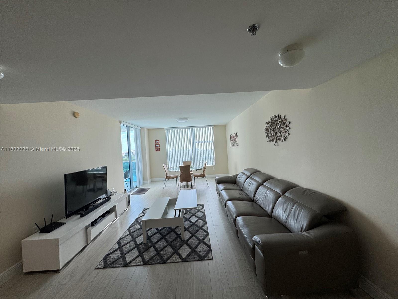 2641 North Flamingo Road, Unit 1001N Sunrise, FL 33323 - Photo 61 of 84 a living room with furniture and a flat screen tv