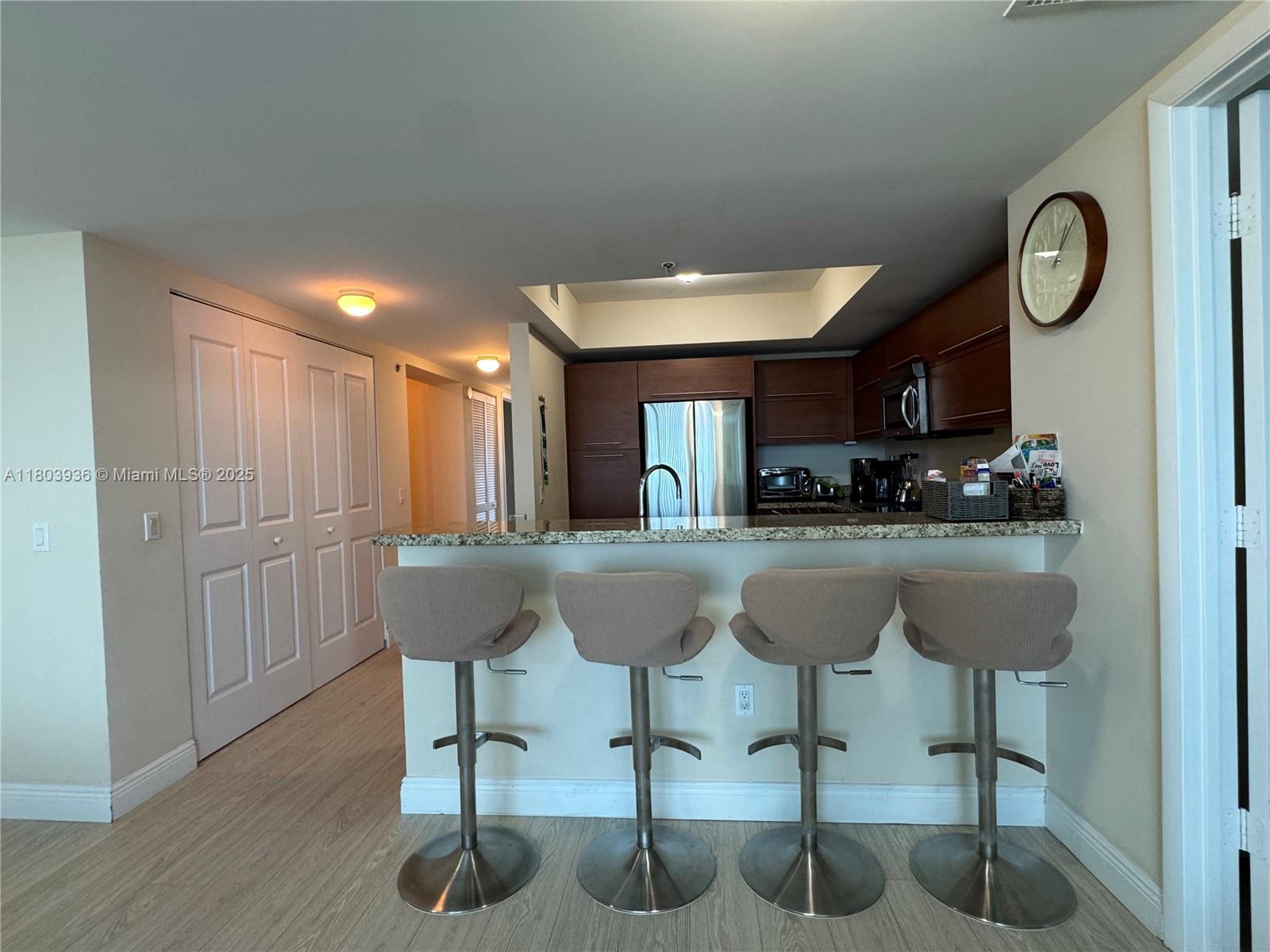 2641 North Flamingo Road, Unit 1001N Sunrise, FL 33323 - Photo 78 of 84 a kitchen with stainless steel appliances granite countertop a refrigerator a sink a stove a dining table and chairs with wooden floor