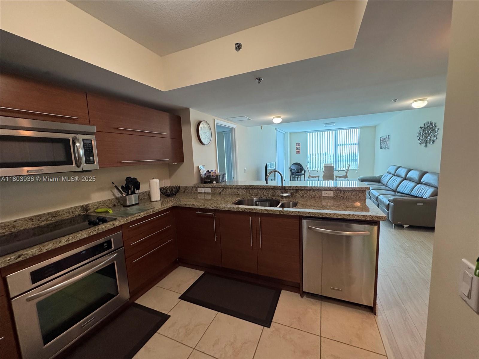 2641 North Flamingo Road, Unit 1001N Sunrise, FL 33323 - Photo 80 of 84 a kitchen with stainless steel appliances kitchen island granite countertop a sink and cabinets