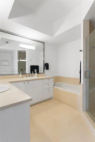 a spacious bathroom with a tub sink and mirror
