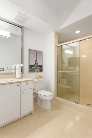 a bathroom with a shower sink vanity mirror and toilet