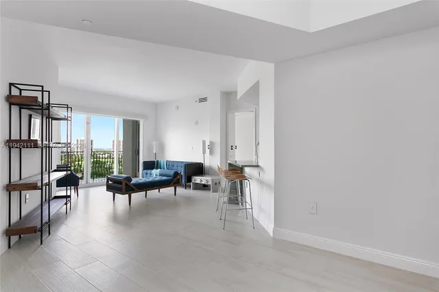 a living room with furniture and large windows