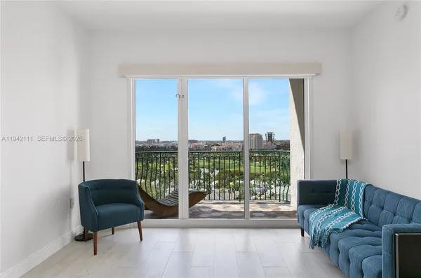 a living room with furniture and a floor to ceiling window