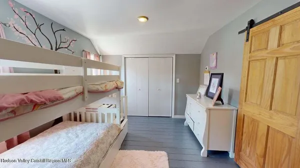 a view of a hallway to a livingroom with wooden floor and furniture