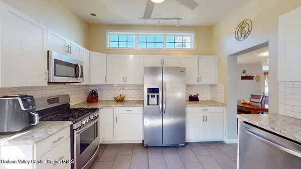 a kitchen with stainless steel appliances granite countertop a refrigerator sink and stove