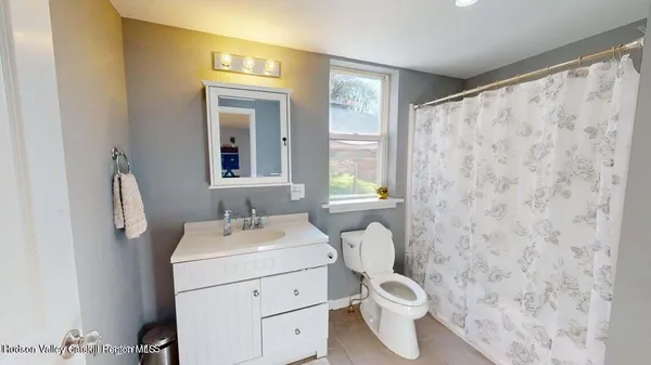 a bathroom with a sink toilet and window