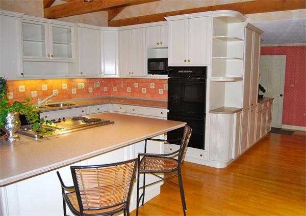 4 Dudley Road Lexington, MA 02421 - Photo 7 of 26 a kitchen with stainless steel appliances granite countertop a refrigerator a stove and white cabinets with wooden floor