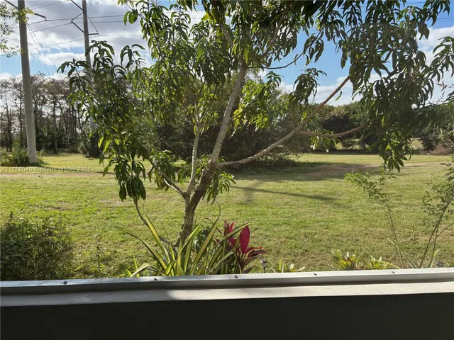 a view of a yard with wooden fence