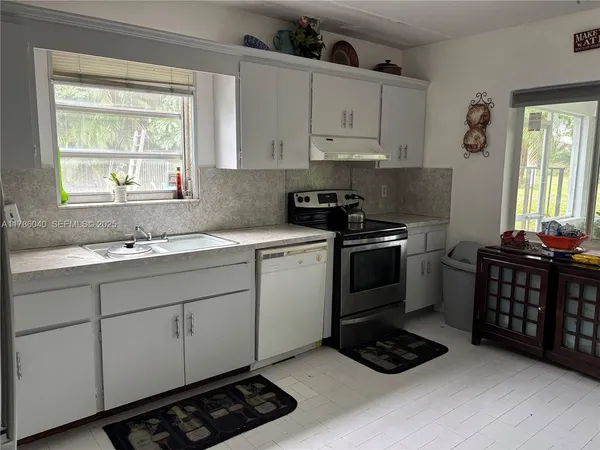 a kitchen with stainless steel appliances a sink stove and cabinets