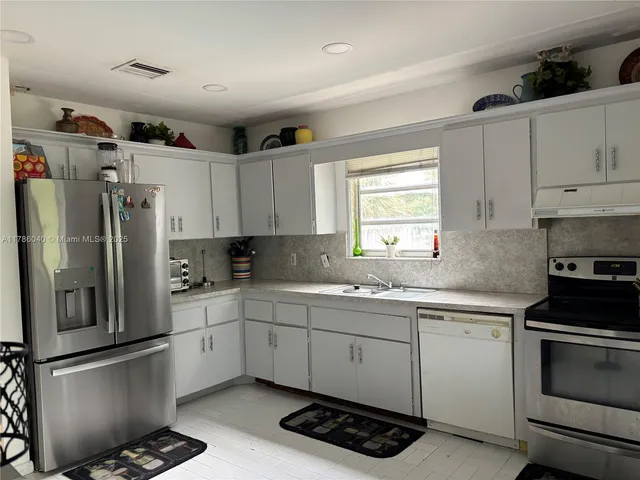 a kitchen with a sink appliances and cabinets
