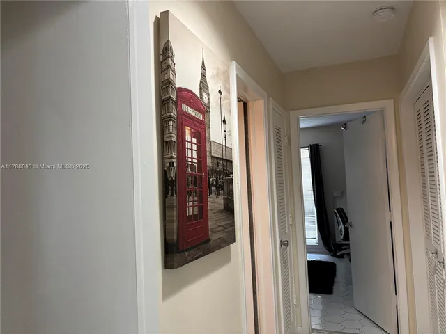 a view of a hallway with closet and a bathroom