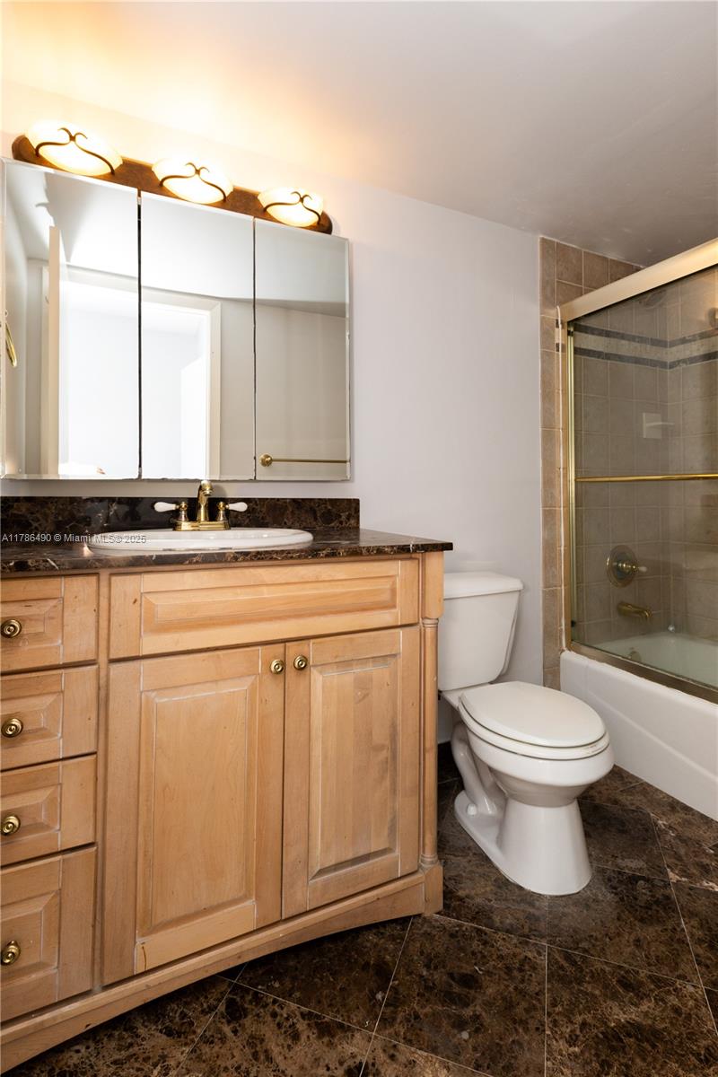 2750 Northeast 183rd Street, Unit 511 Aventura, FL 33160 - Photo 12 of 36 a bathroom with a granite countertop toilet sink and mirror
