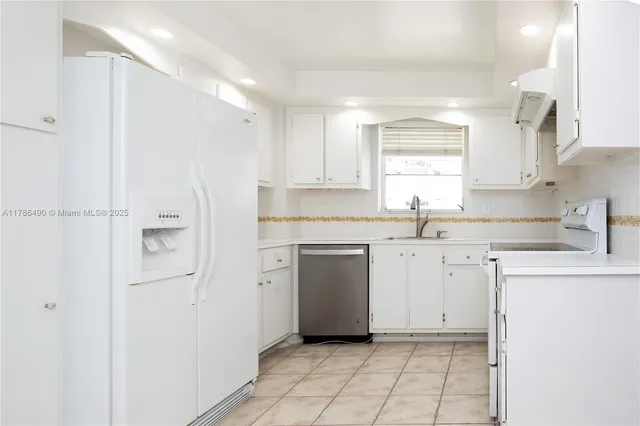 a kitchen with white cabinets and white appliances