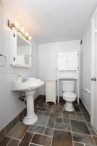a bathroom with a toilet a sink and a mirror