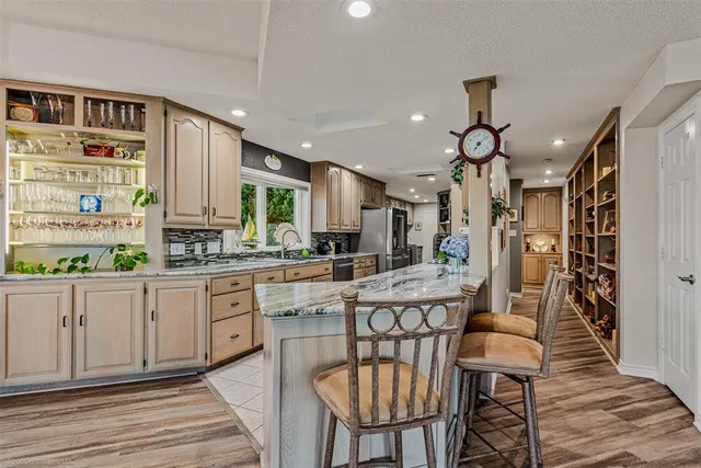a kitchen with stainless steel appliances kitchen island granite countertop a stove a sink and a refrigerator