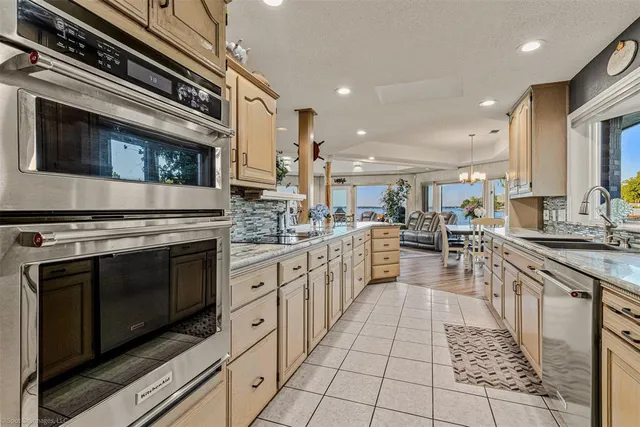 a kitchen with stainless steel appliances kitchen island granite countertop a stove a sink and a microwave