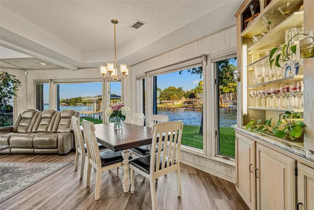 a view of a dining room with furniture a chandelier and wooden floor