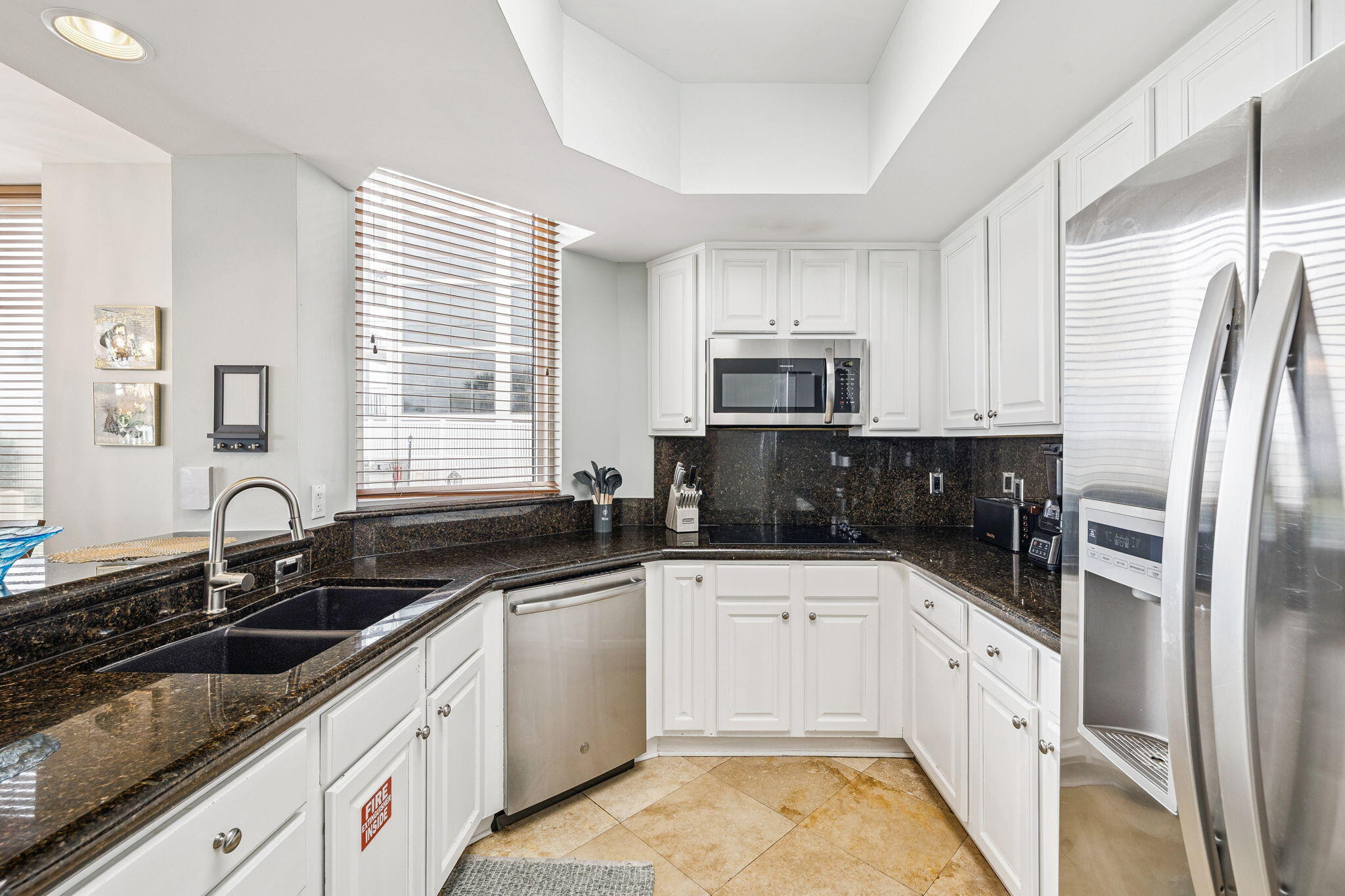 1048 Highway 98, Unit 106W Destin, FL 32541 - Photo 13 of 37 a kitchen with a sink a stove a microwave and cabinets