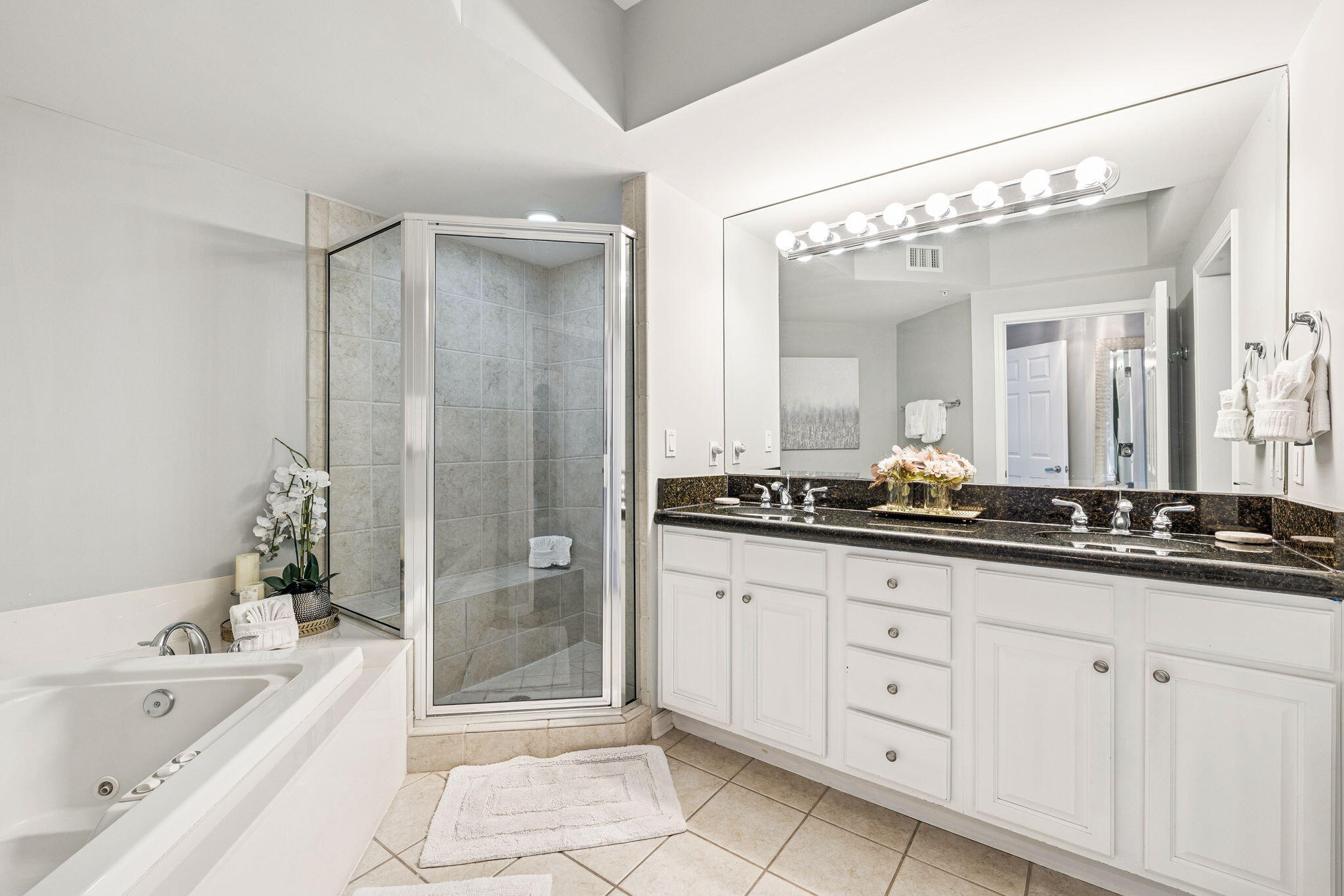 1048 Highway 98, Unit 106W Destin, FL 32541 - Photo 15 of 37 a bathroom with a granite countertop sink a large mirror and a bathtub