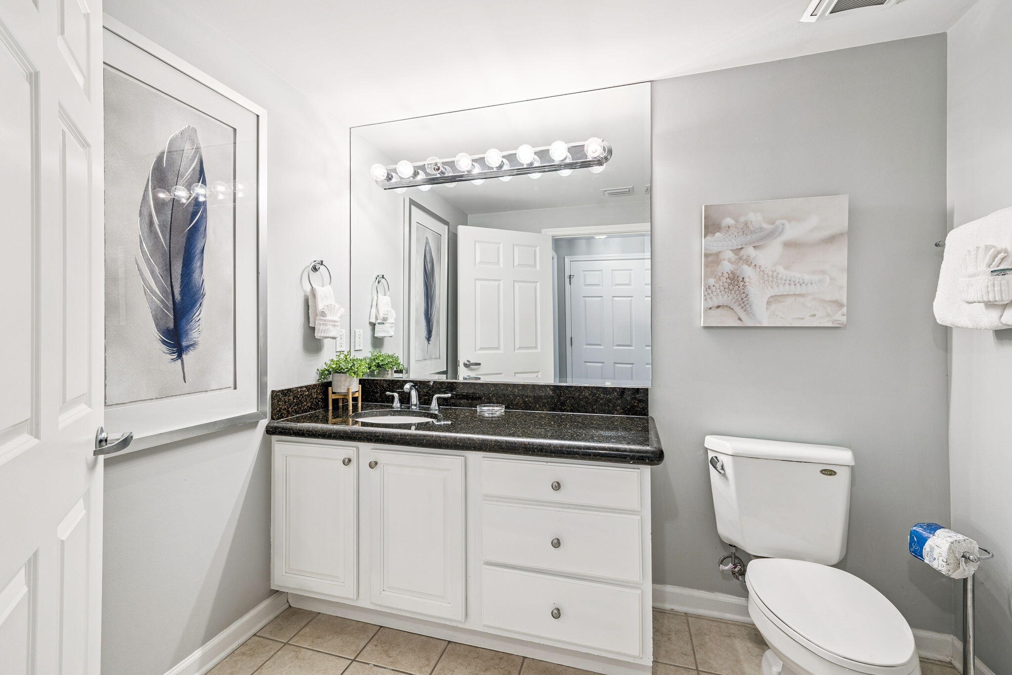 1048 Highway 98, Unit 106W Destin, FL 32541 - Photo 21 of 37 a bathroom with a toilet a sink and mirror