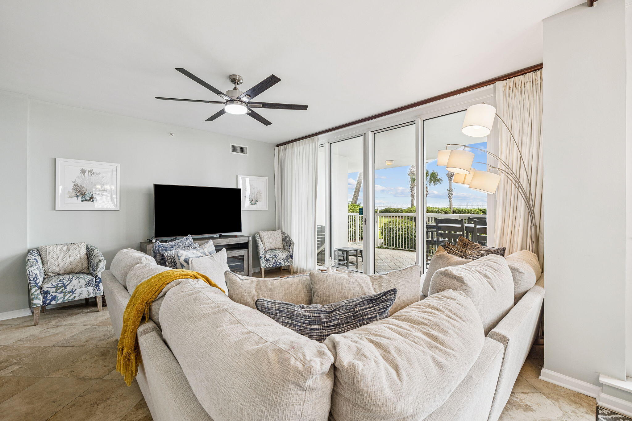 1048 Highway 98, Unit 106W Destin, FL 32541 - Photo 9 of 37 a living room with furniture a flat screen tv and a large window