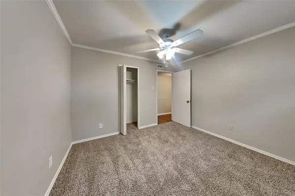 an empty room with chandelier fan
