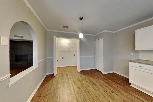 a view of a room with wooden floor and cabinets