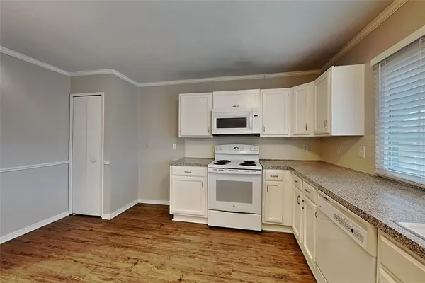 a kitchen with stainless steel appliances a white cabinets and a stove top oven