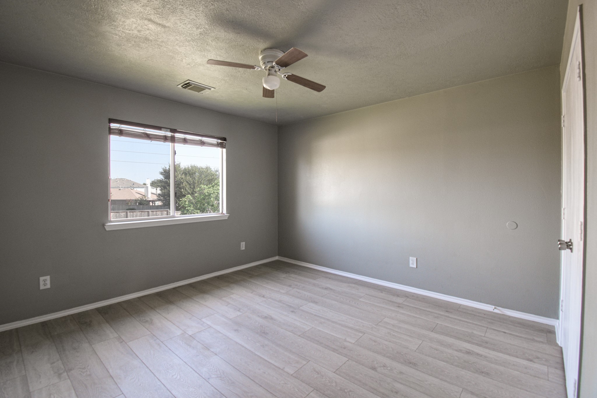 19362 Moss Meadow Lane Katy, TX 77449 - Photo 18 of 35 an empty room with wooden floor chandelier fan and windows