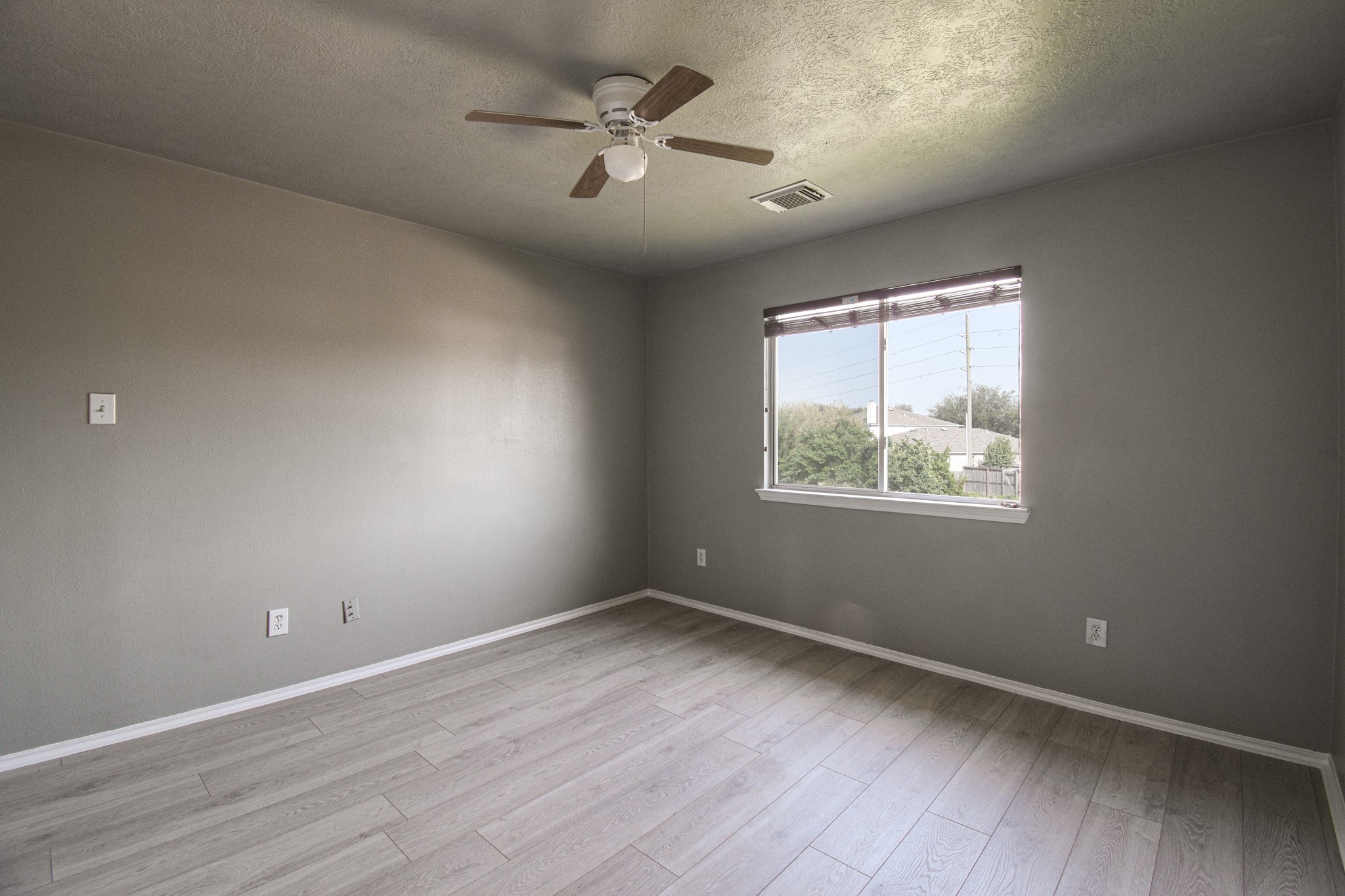 19362 Moss Meadow Lane Katy, TX 77449 - Photo 19 of 35 an empty room with wooden floor ceiling fan and windows